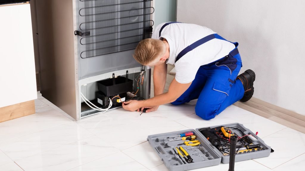 male technician checking refrigerator